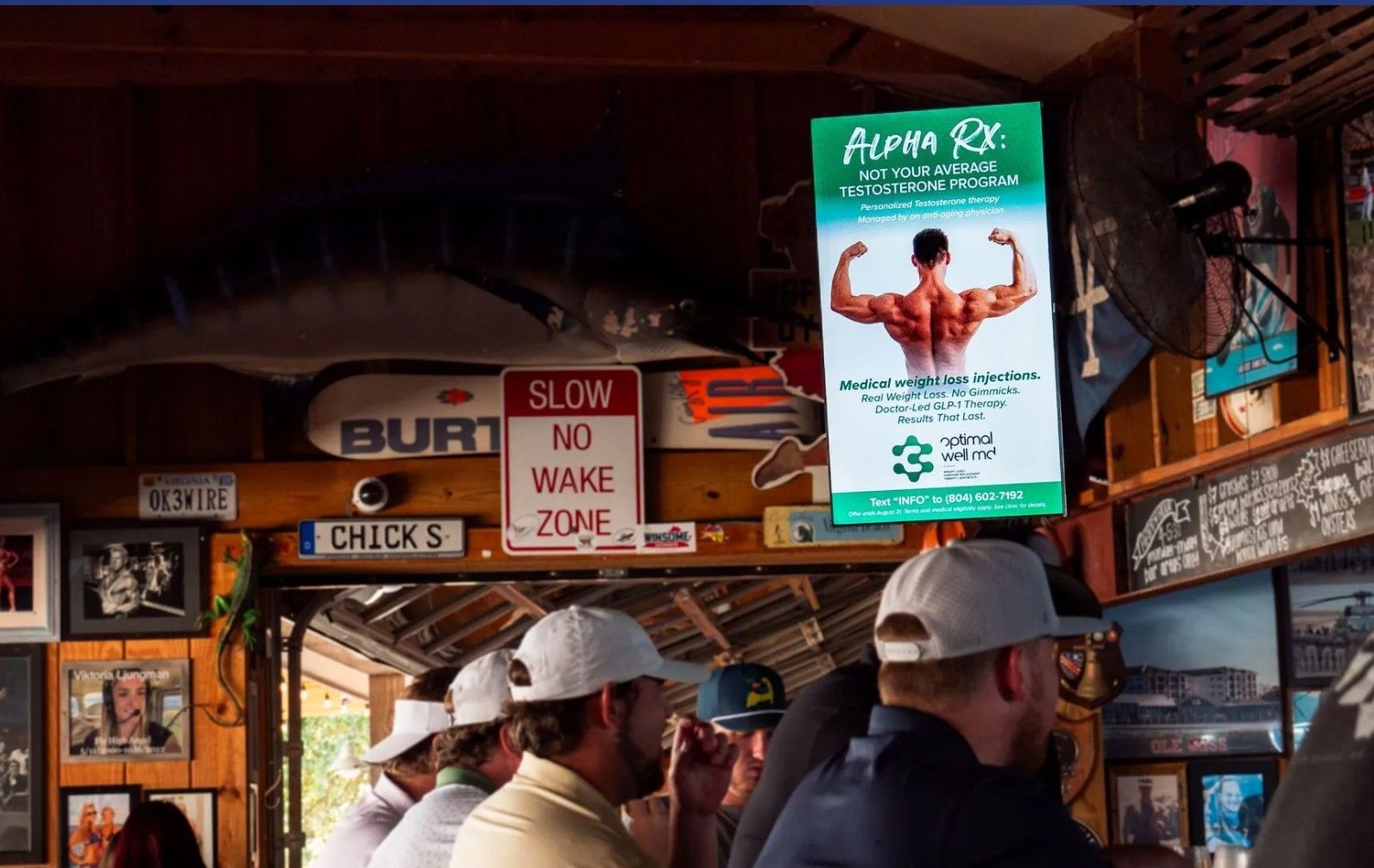 People at a bar under a sign for an 