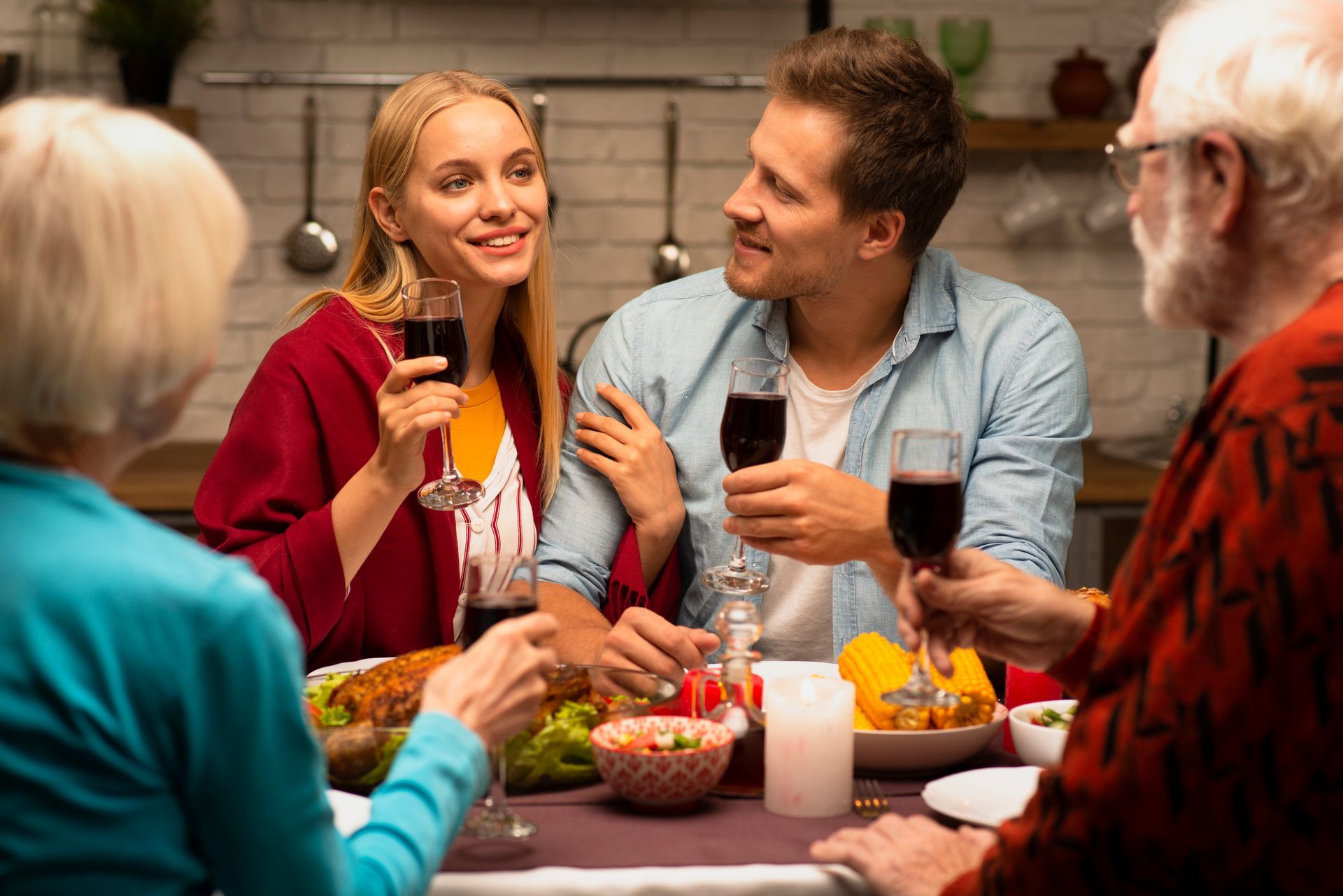 Family enjoying a meal, toasting with wine at a dining table.