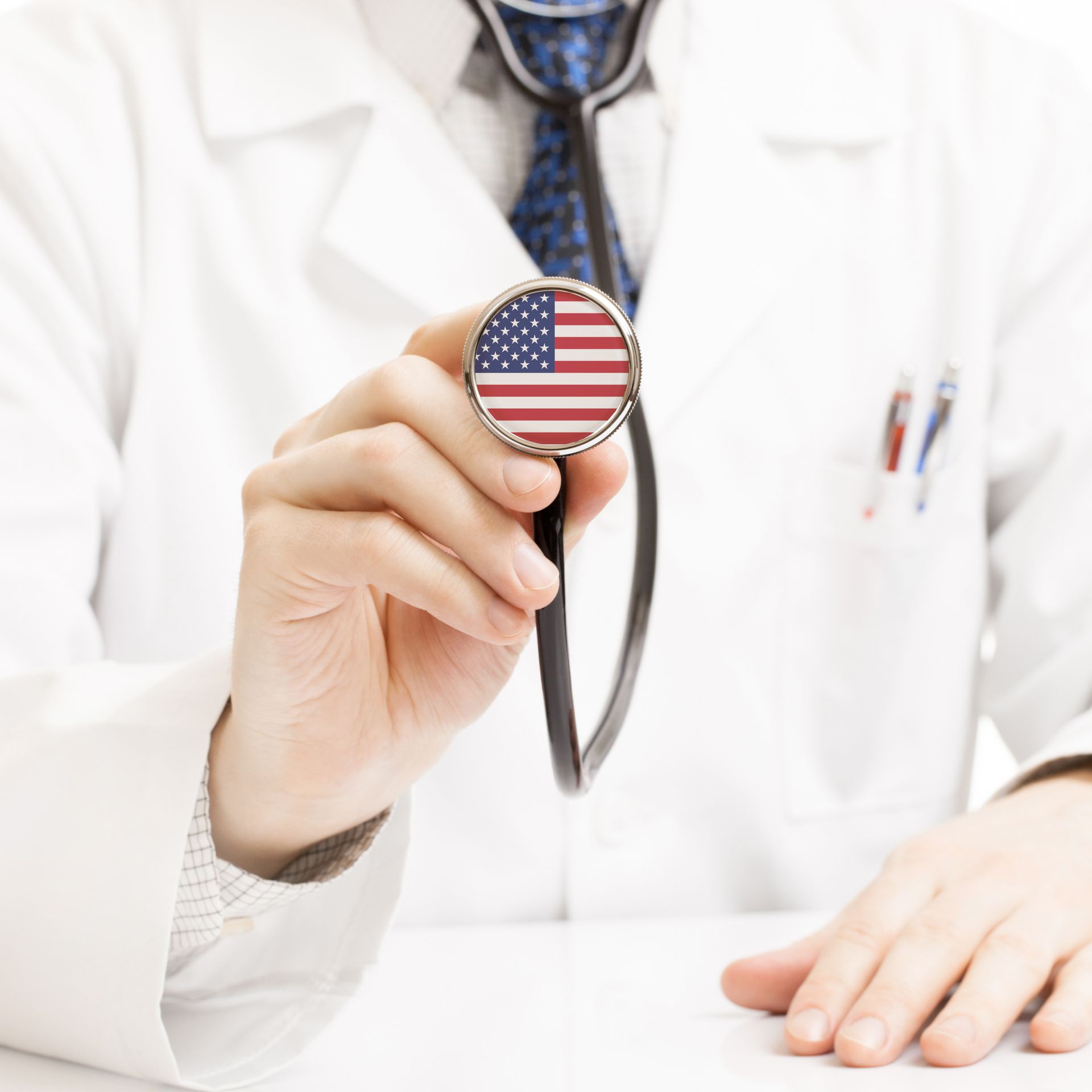 A doctor is holding a stethoscope with the american flag on it