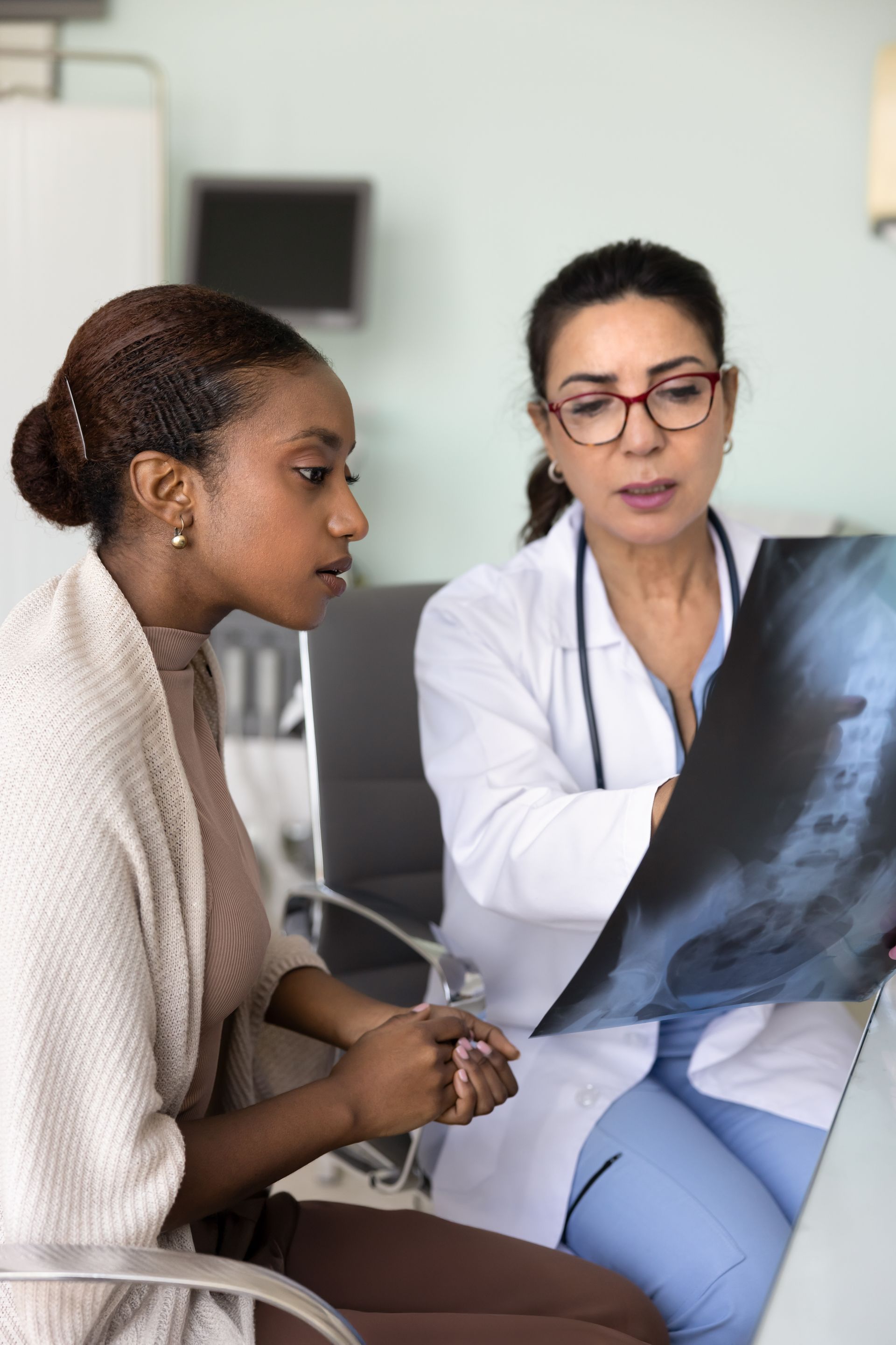 A doctor is looking at an x-ray with a patient.