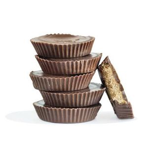 A stack of chocolate cups with a bite taken out of one of them