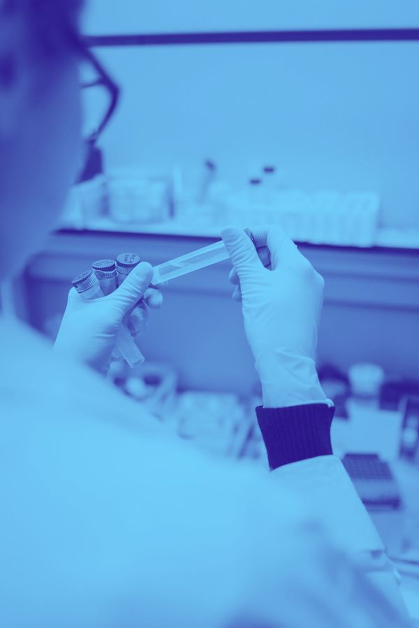 A scientist is holding a test tube in a laboratory.