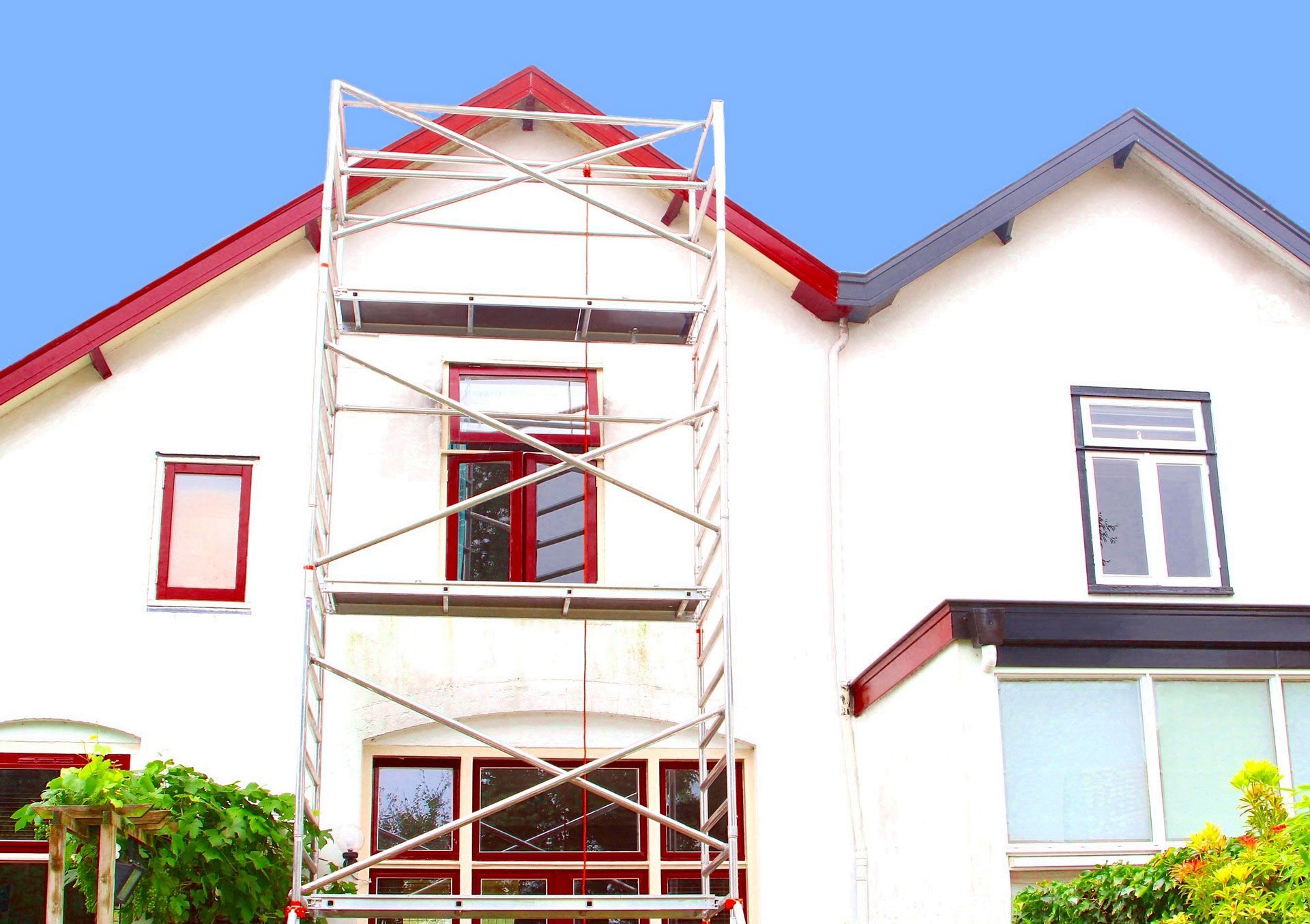 A white house with a scaffolding in front of it