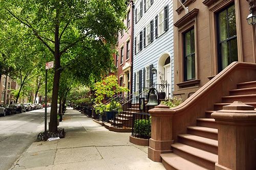 Looking down a Brooklyn street lined with brownstones.