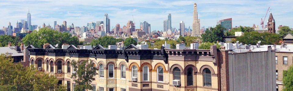Brooklyn brownstones with the Manhattan skyline in the background.