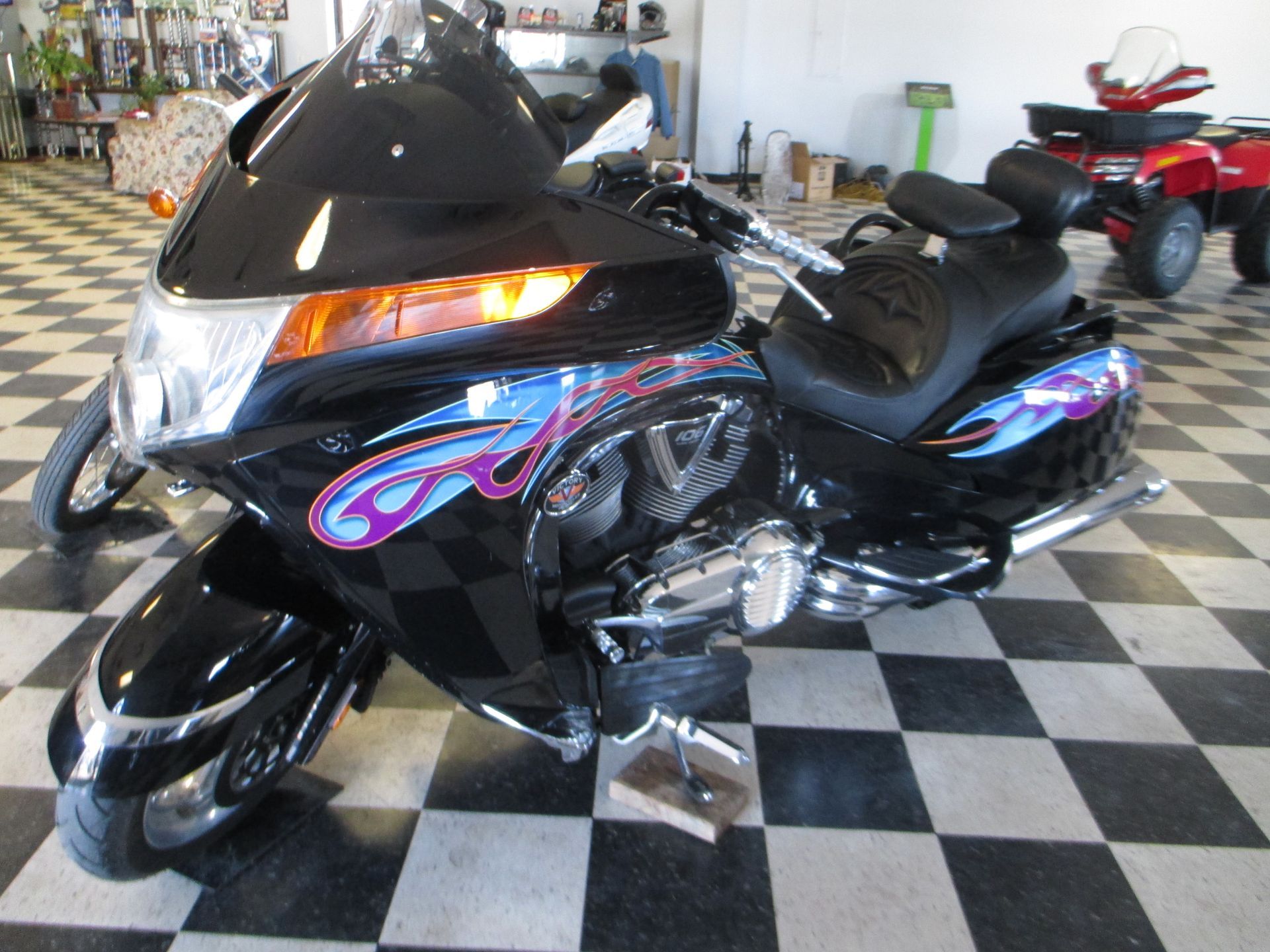 A black motorcycle is parked on a checkered floor