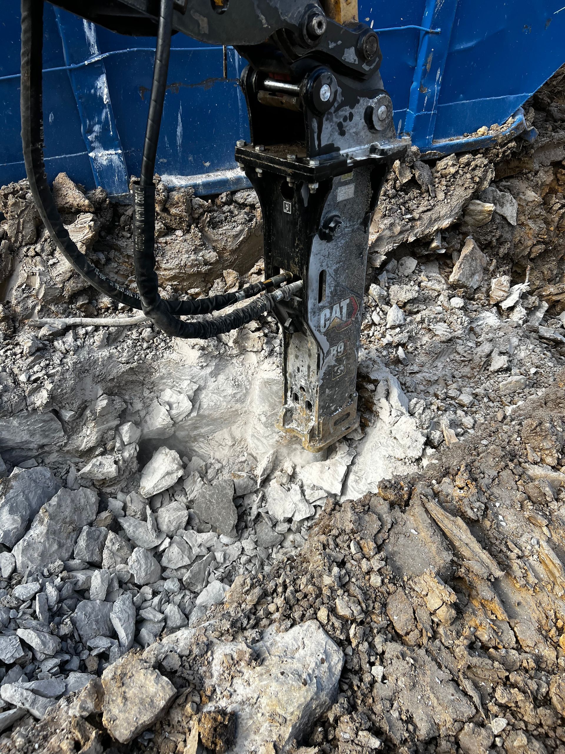 A machine is breaking concrete in a pile of rocks.