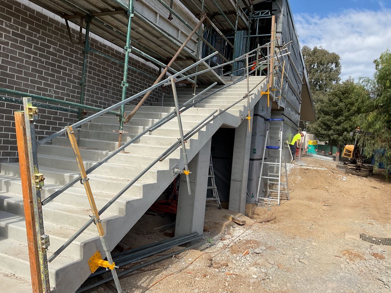 A concrete staircase is being built on the side of a building.