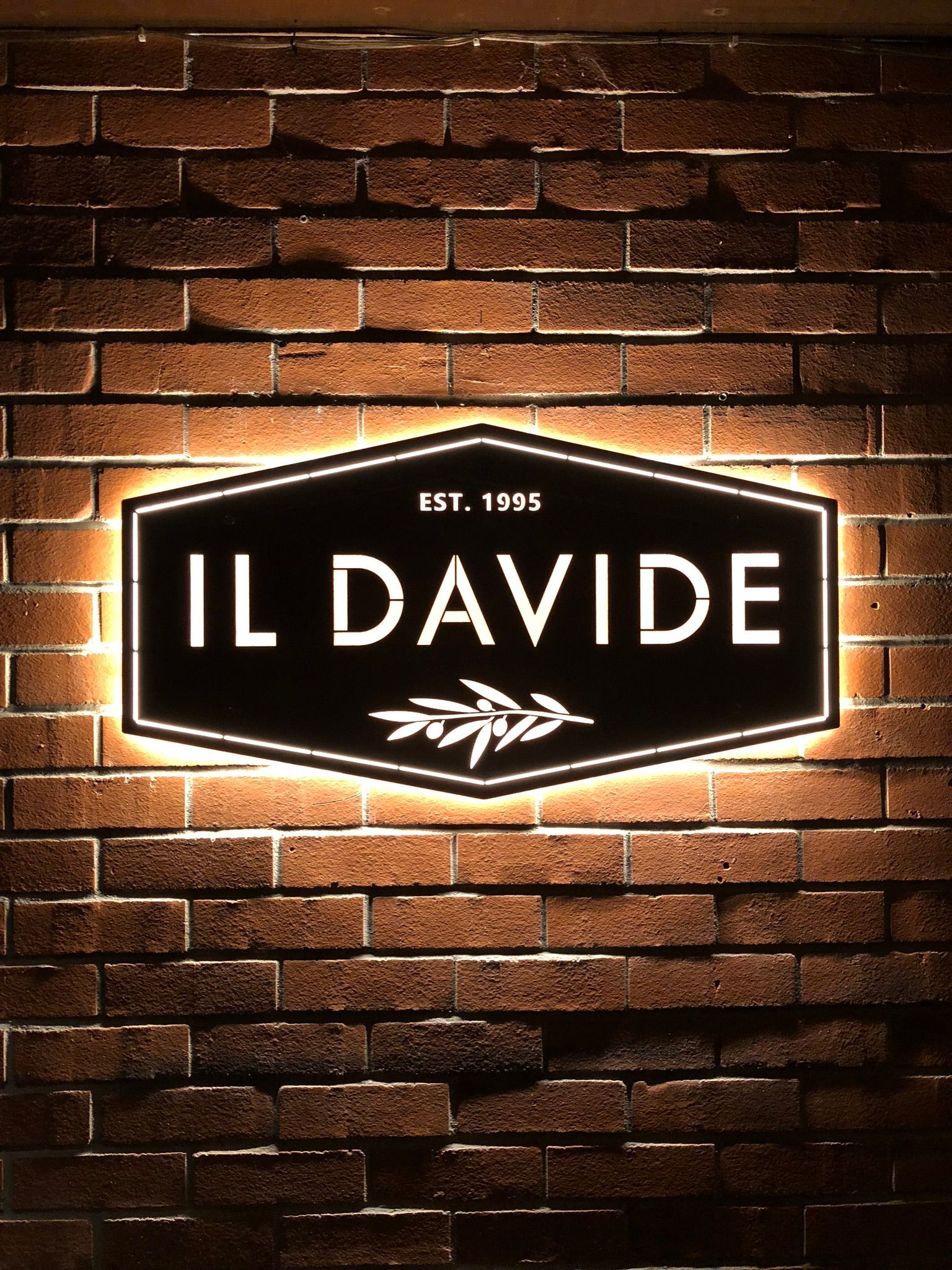A sign on a brick wall that says il davide