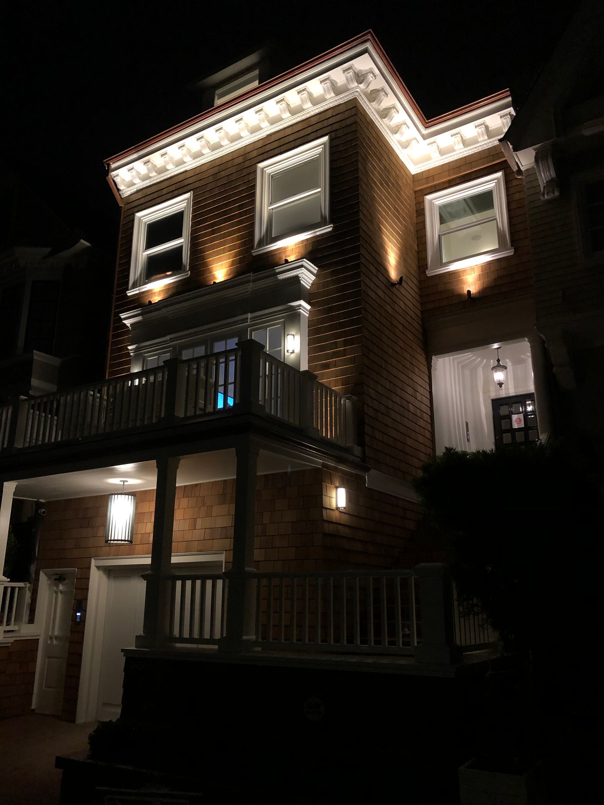 A large brick house is lit up at night