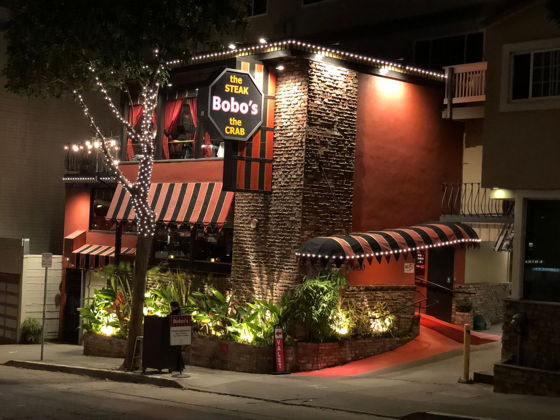 A restaurant called bobo 's is lit up at night