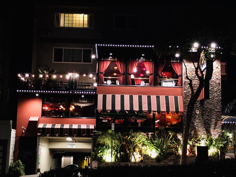 A building with a striped awning is lit up at night
