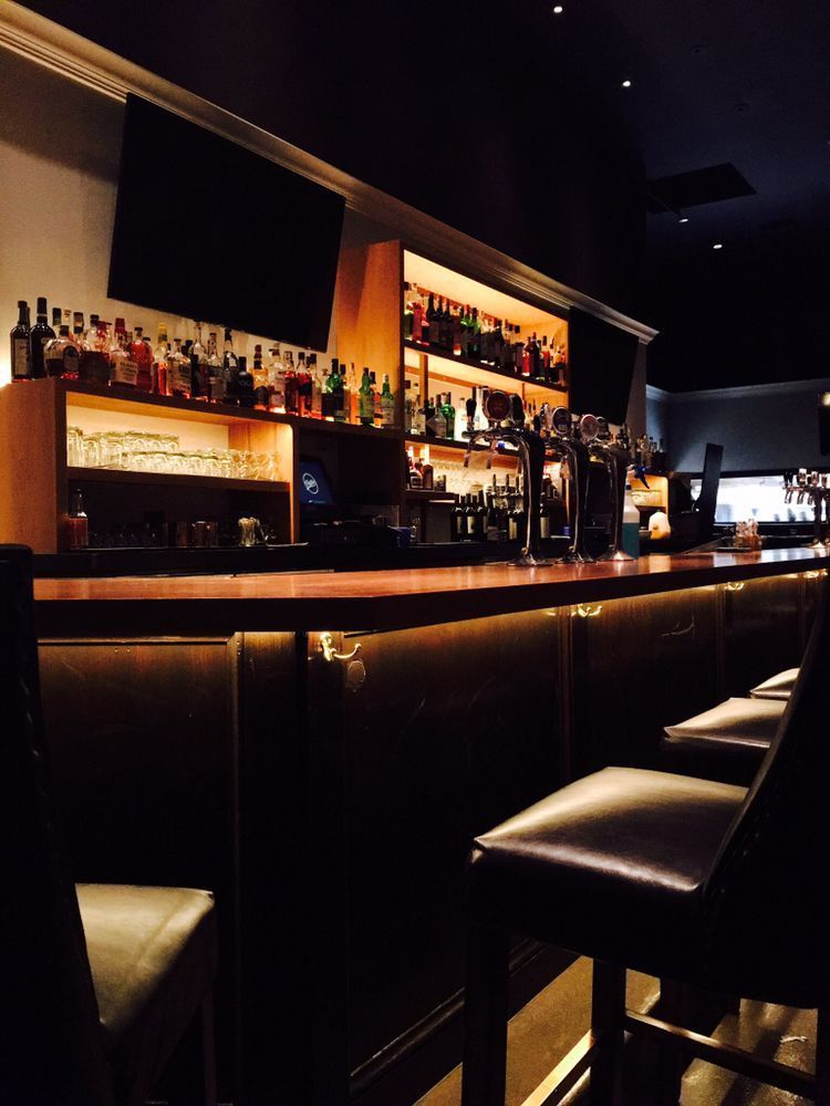 A bar with a lot of bottles on the shelves