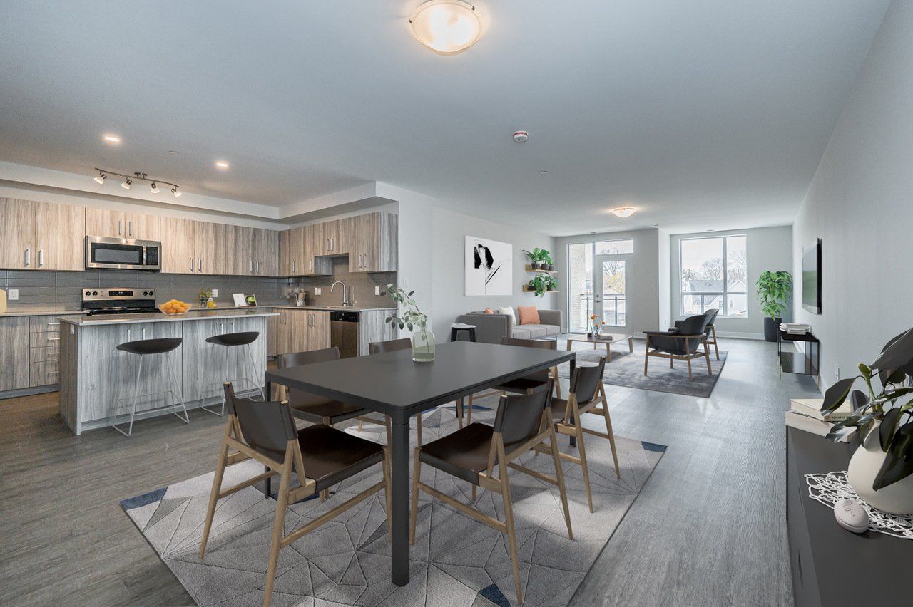 A living room with a dining table and chairs and a kitchen.