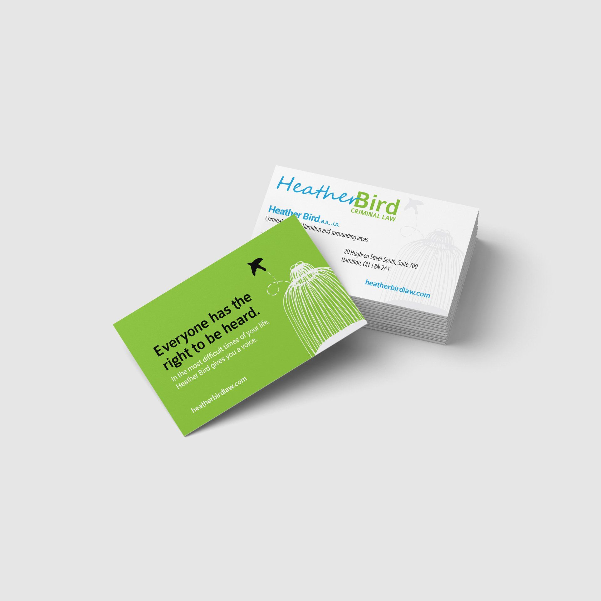 Two business cards are stacked on top of each other on a white surface.