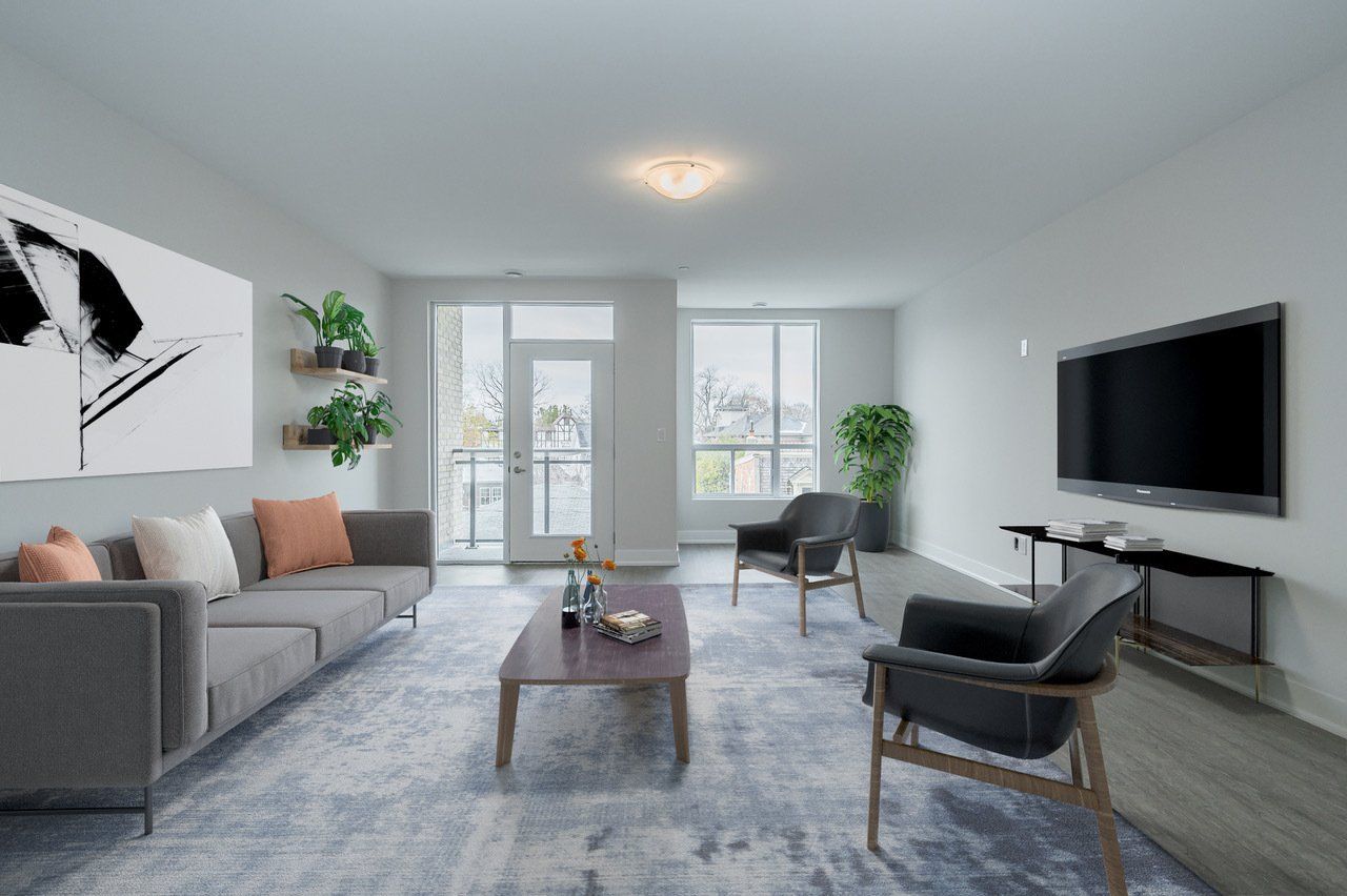 A living room with a couch , chair , coffee table and television.