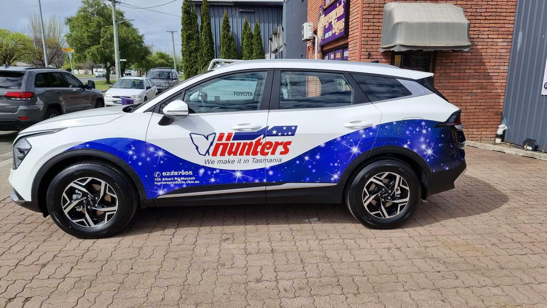 A row of cars are parked on the side of a road.