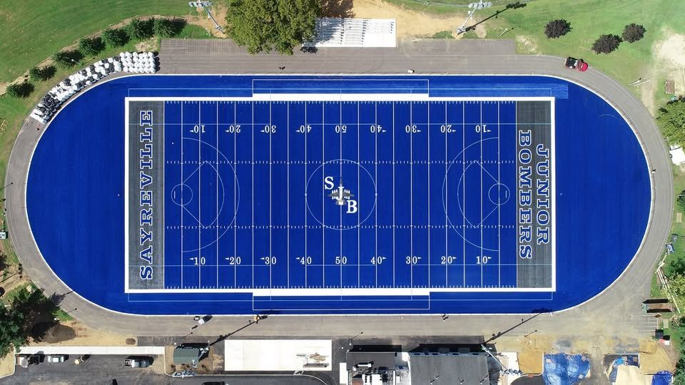 Overhead view of a blue football field with a track surrounding it.
