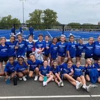Cheerleaders in blue and white uniforms pose on a blue track.