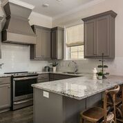 Kitchen with gray cabinets, stainless steel appliances, and granite countertop.