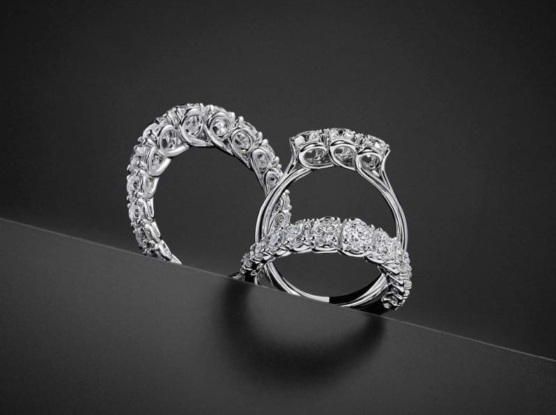 Due anelli di diamanti decorati su una superficie nera.