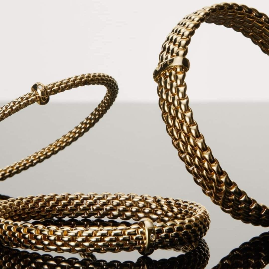 Braccialetti a catena in oro, superficie riflettente.