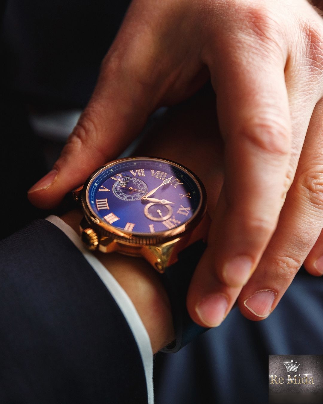 Persona che indossa un orologio d'oro con il quadrante blu e controlla l'ora.