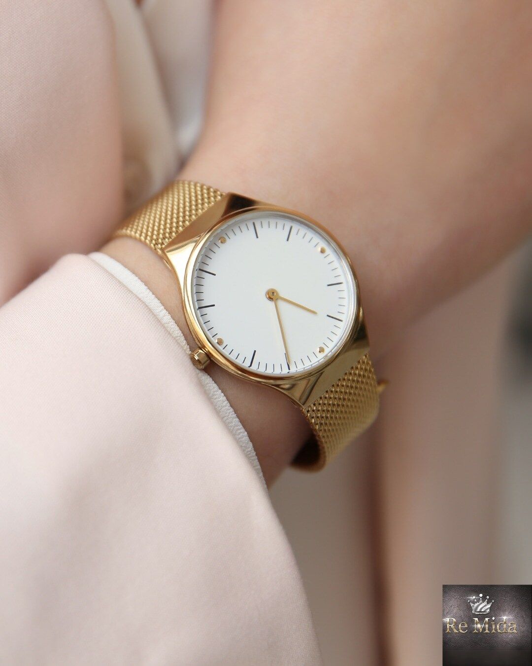 Orologio da polso in oro, quadrante bianco, cinturino a maglie.