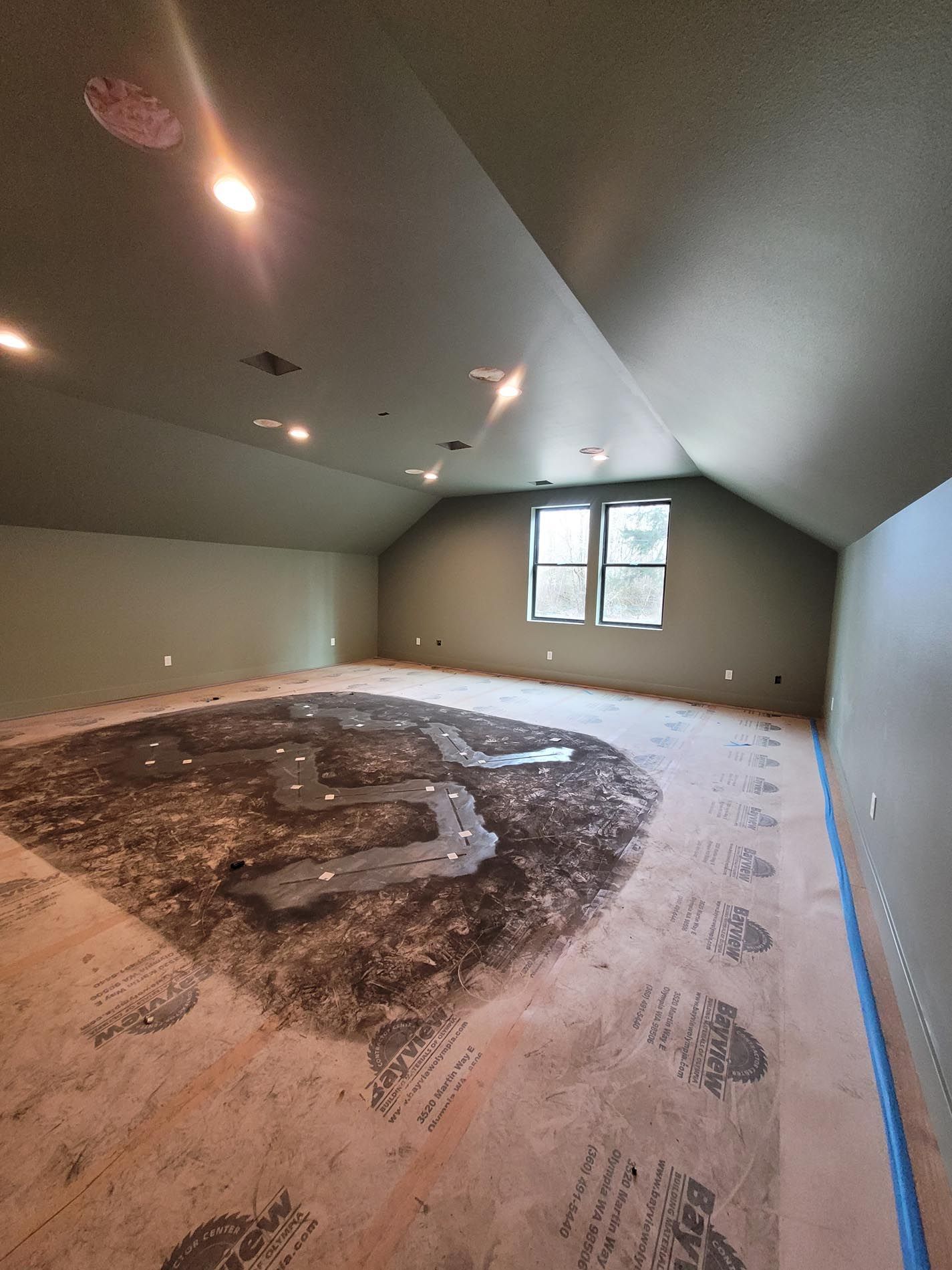 A room with a ceiling that is very high and a lot of footprints on the floor.