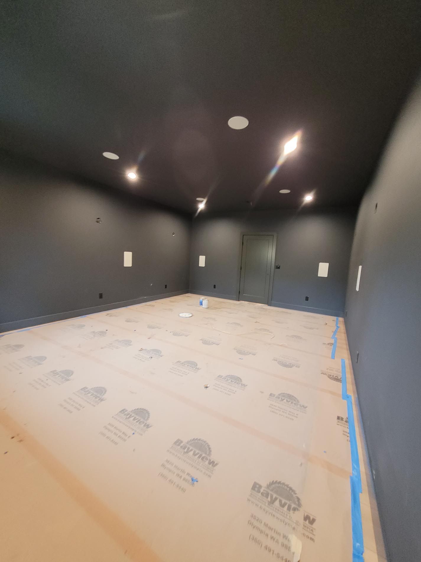 An empty room with black walls and a brown floor