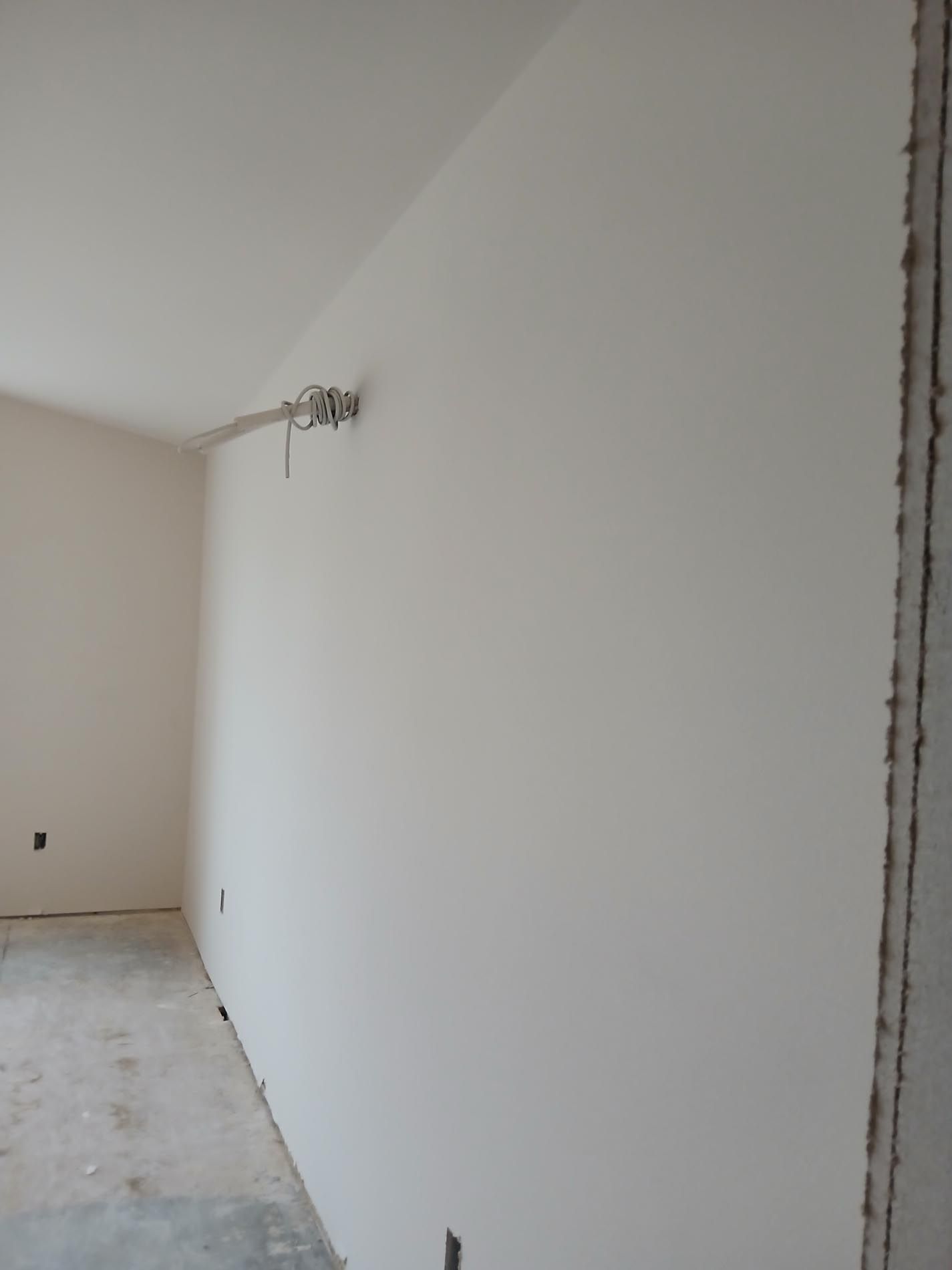 A room with a white wall and a wooden floor