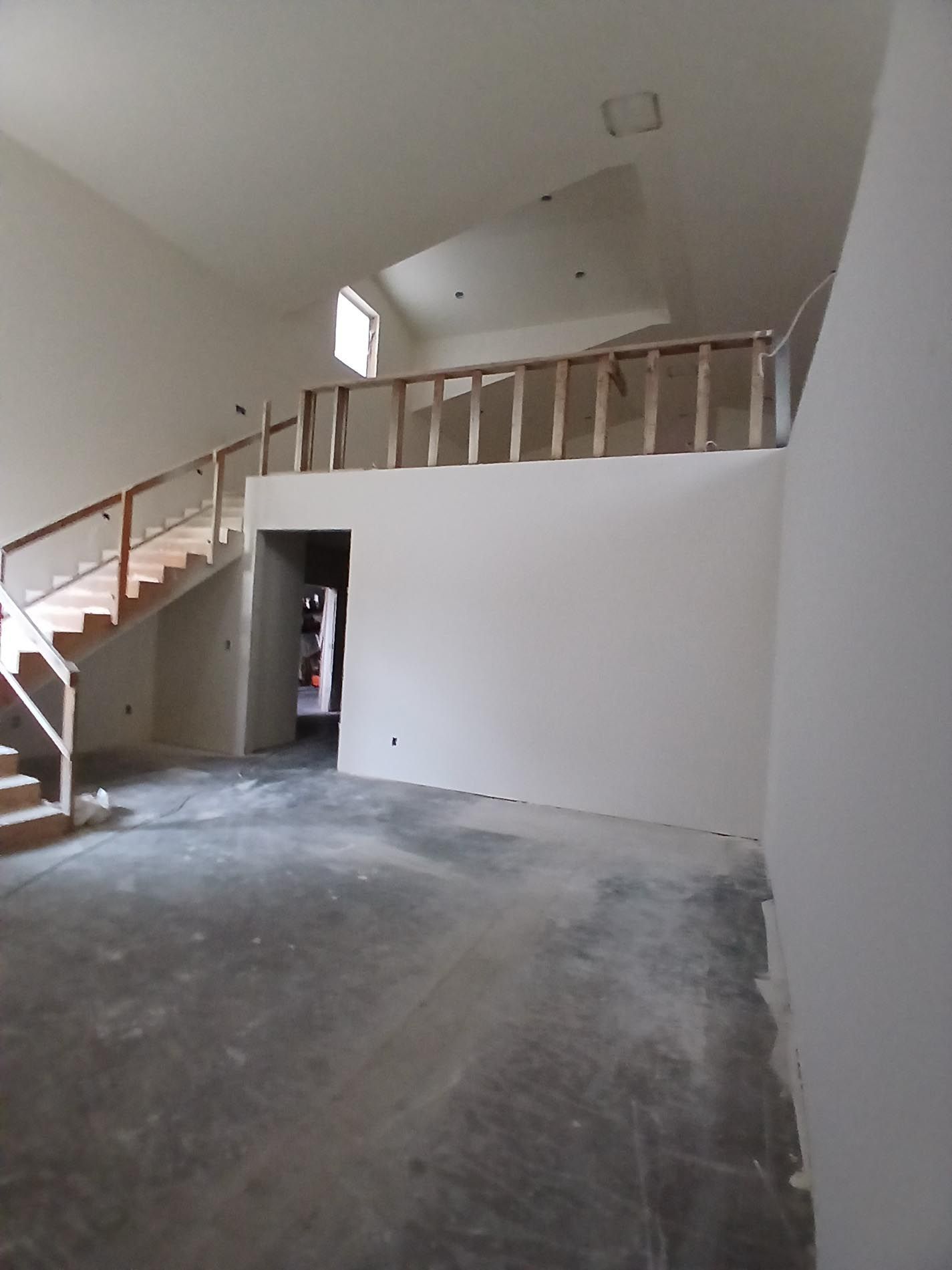 An empty room with stairs going up to the second floor