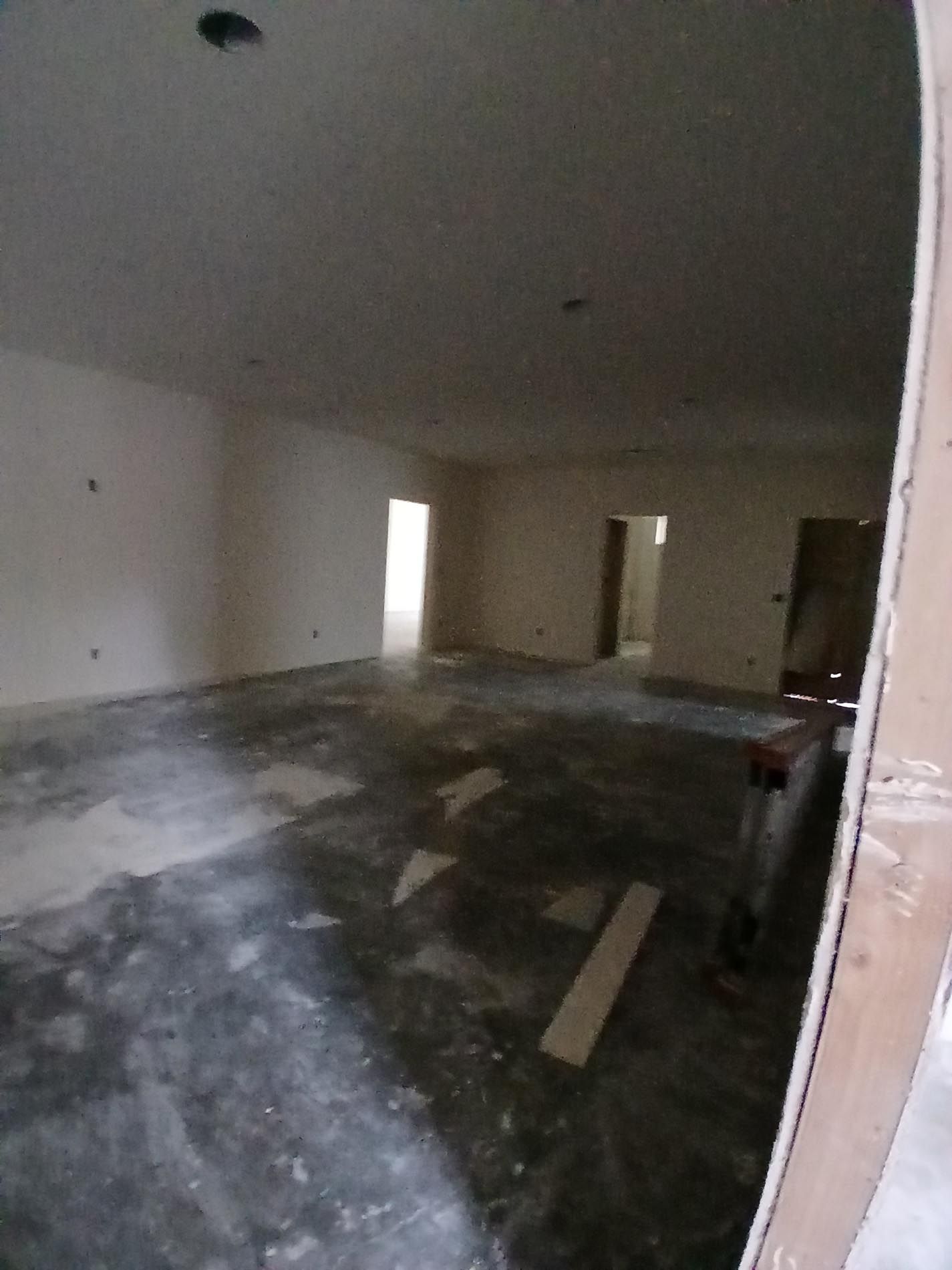 An empty room with a concrete floor and white walls