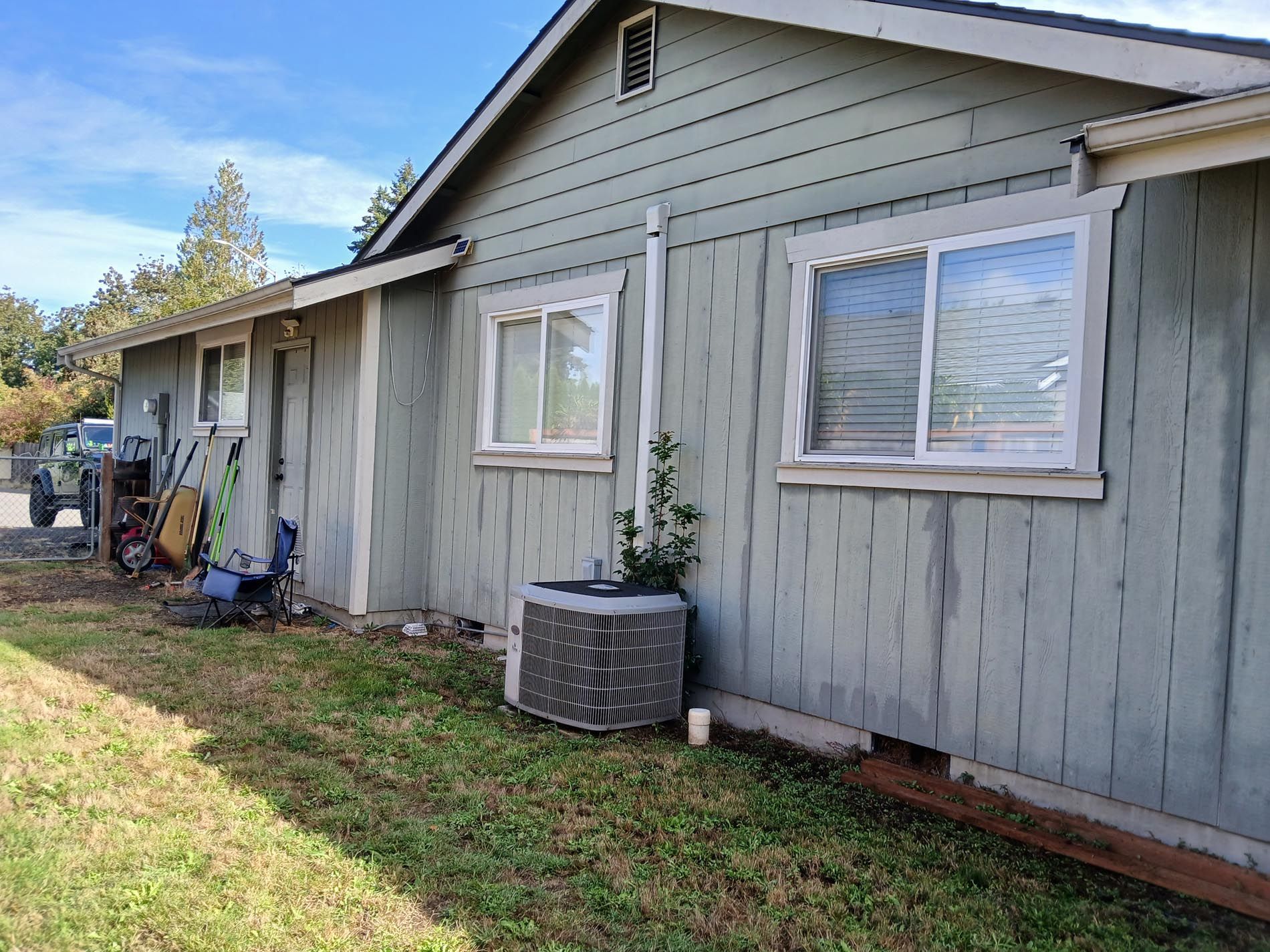 A house with a lot of windows and an air conditioner on the side of it.
