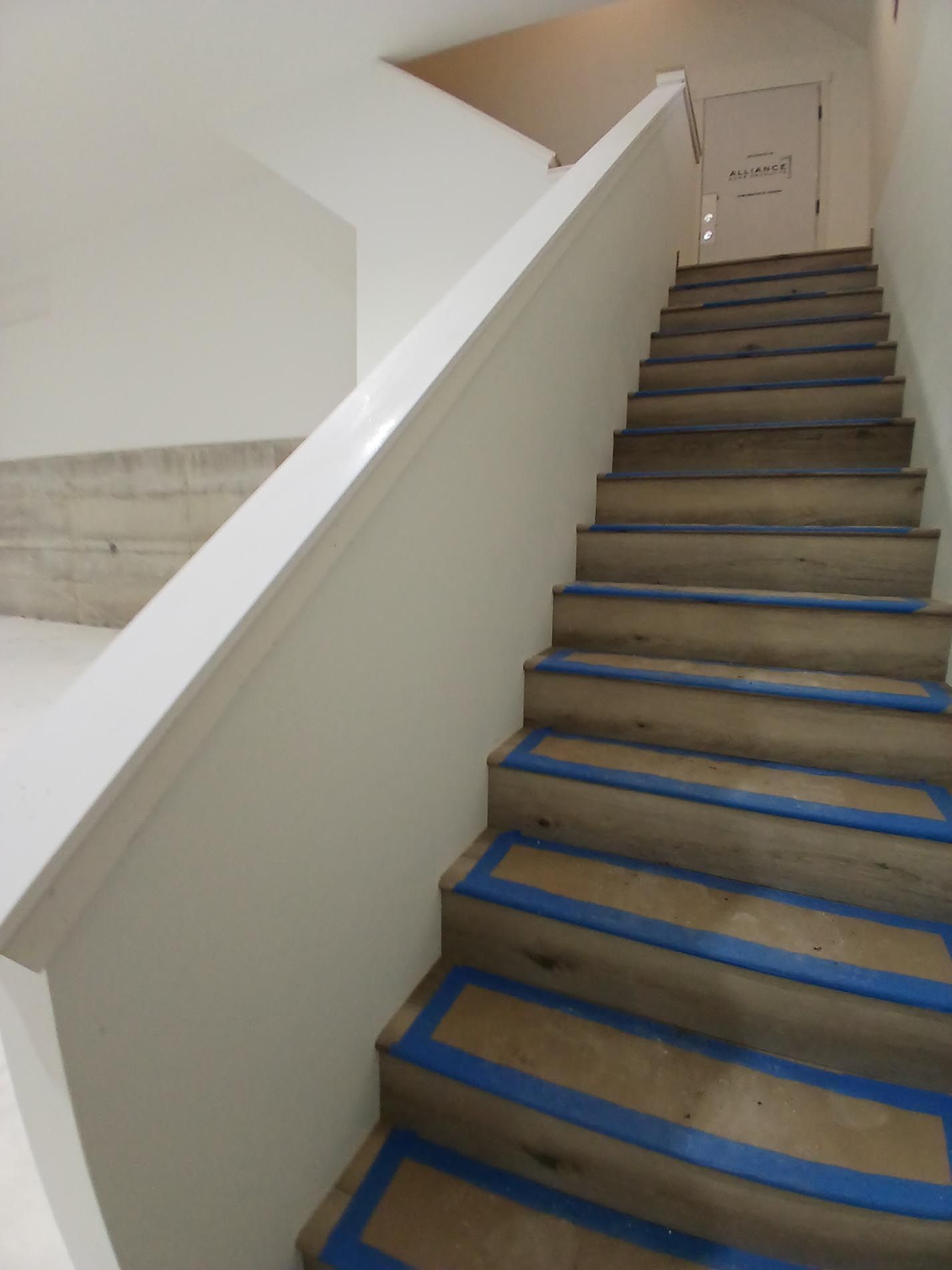 A set of stairs with blue tape on the steps