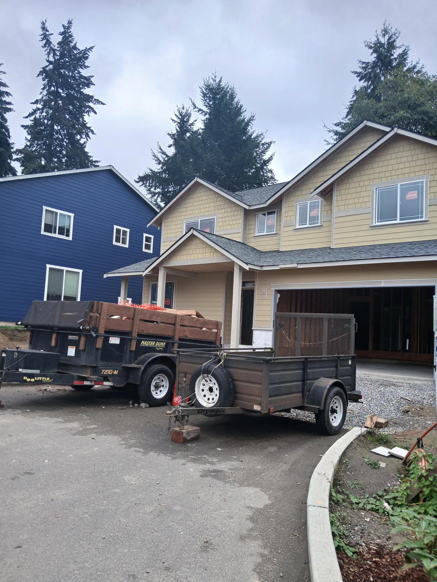 A trailer is parked in front of a house under construction