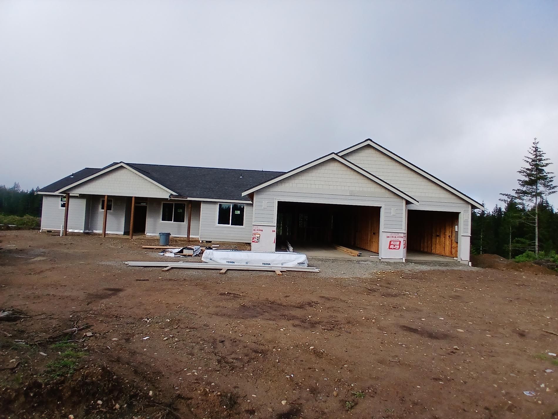 A house that is being built with a lot of dirt in front of it