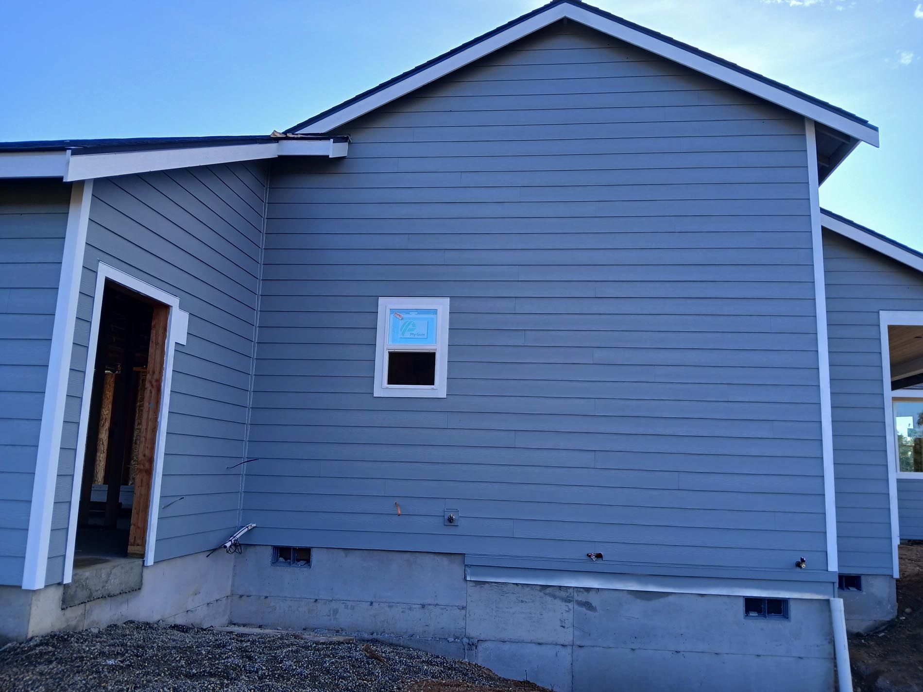 A gray house with a window on the side