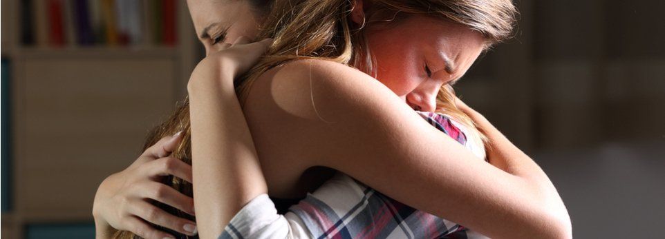 abbraccio tra due ragazze dopo un decesso