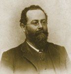 A man with a beard and glasses is wearing a suit and tie.