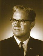 A man in a suit and tie is wearing glasses.