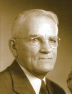 A man in a suit and tie is wearing glasses.