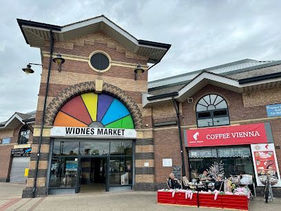 Rugby match at a stadium under a purple and pink sunset; players on the field, spectators in the stands.