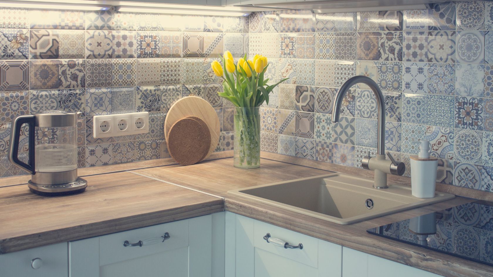Kitchen with a wooden countertop, patterned backsplash, and yellow tulips in a vase.