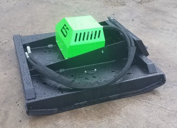 A green and black machine is sitting on the ground.