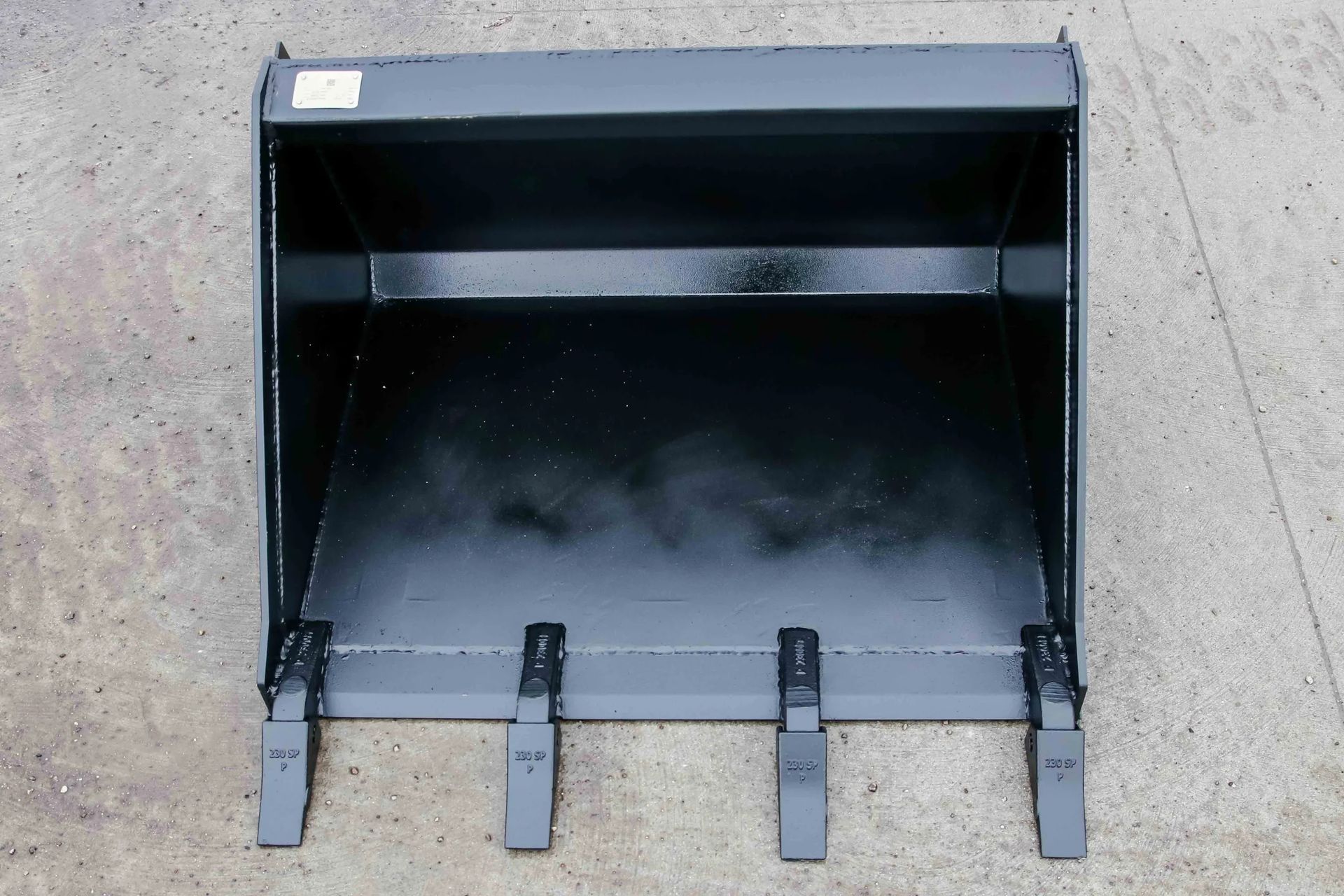 A black bucket is sitting on a concrete surface