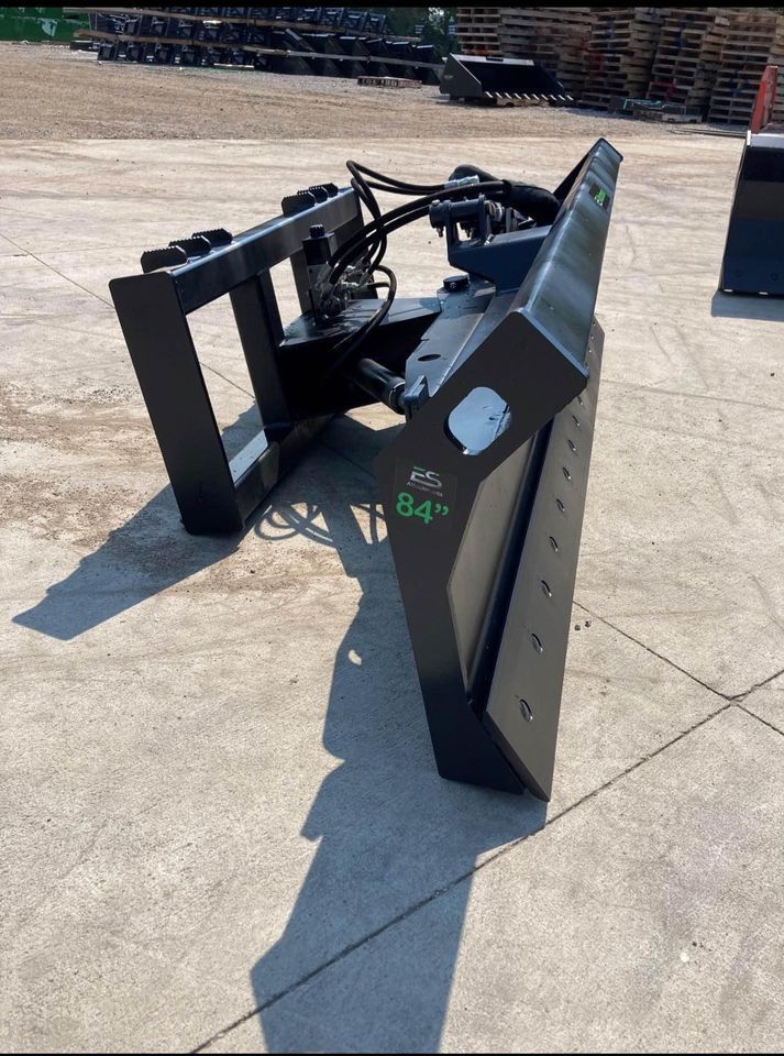 A snow plow is sitting on a concrete surface