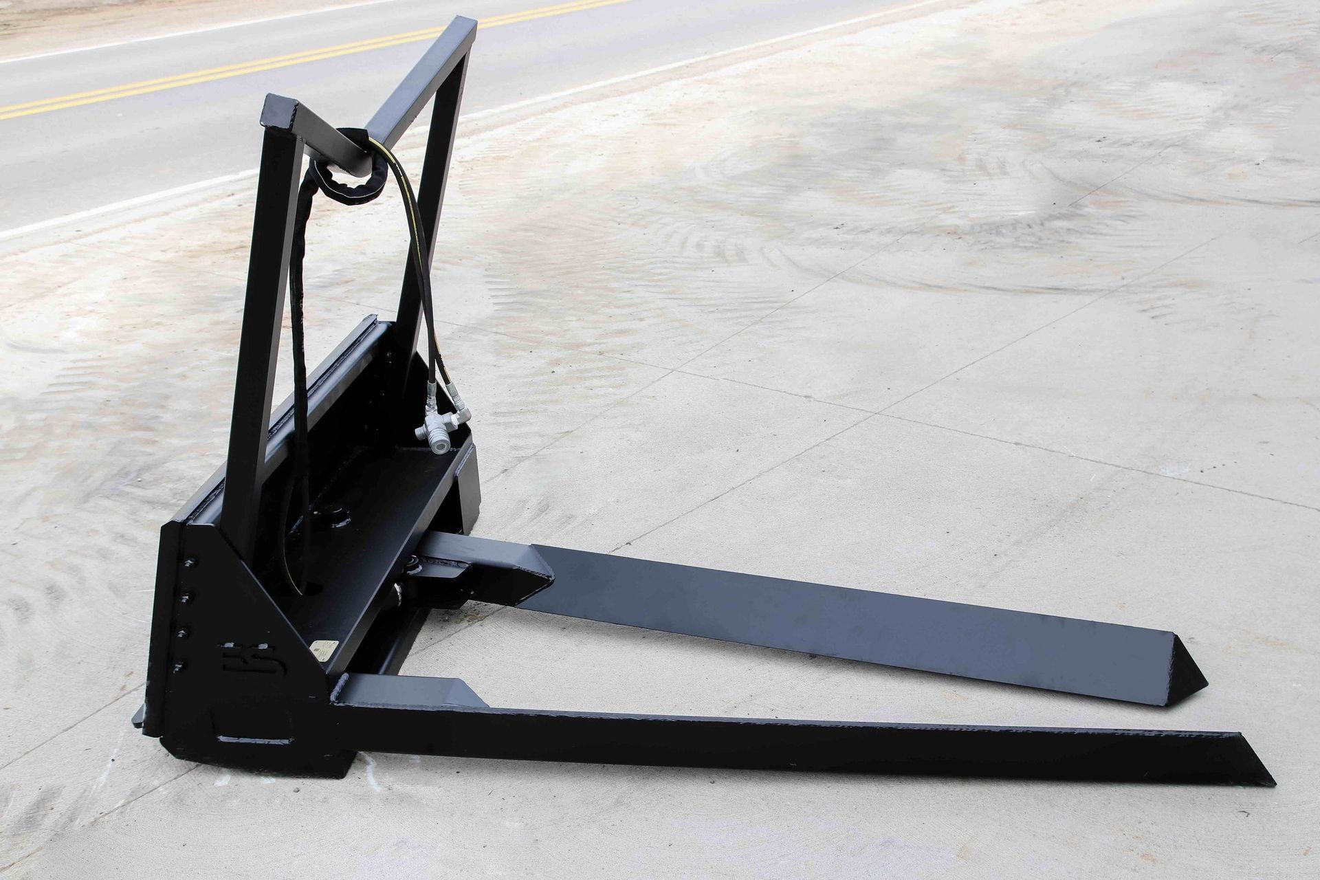 A black forklift is sitting on a white surface.