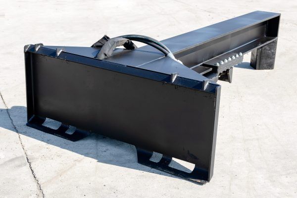 A black metal object is sitting on a concrete surface.