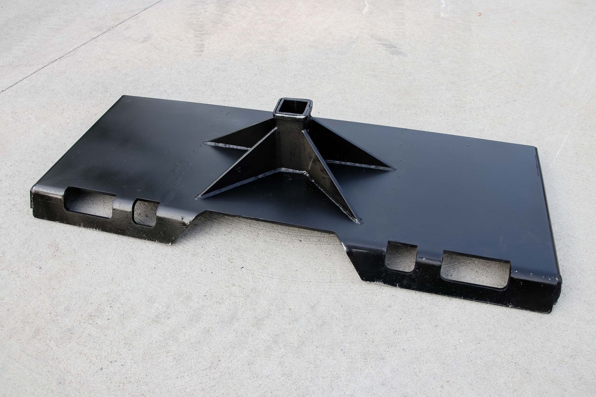 A black metal object is sitting on a white surface.